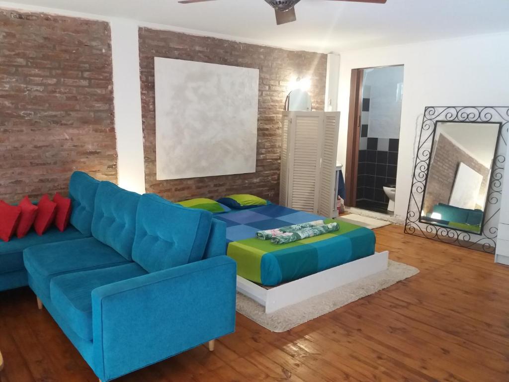 sala de estar con sofá azul y pared de ladrillo en CASA DE RELAX CON PISCINA en Paraná