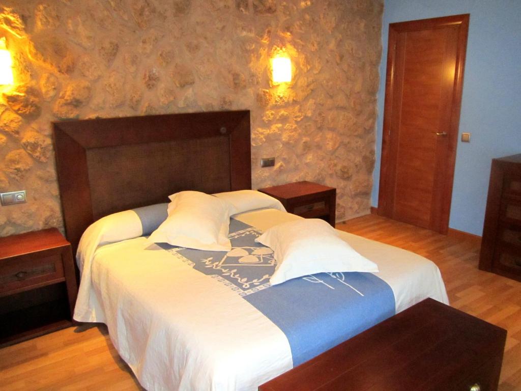 Un dormitorio con una cama grande con sábanas blancas. en Apartamentos Almagro, en Almagro