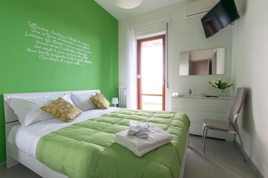 a green bedroom with a bed with a green wall at Terrazze Dannunziane in Pescara