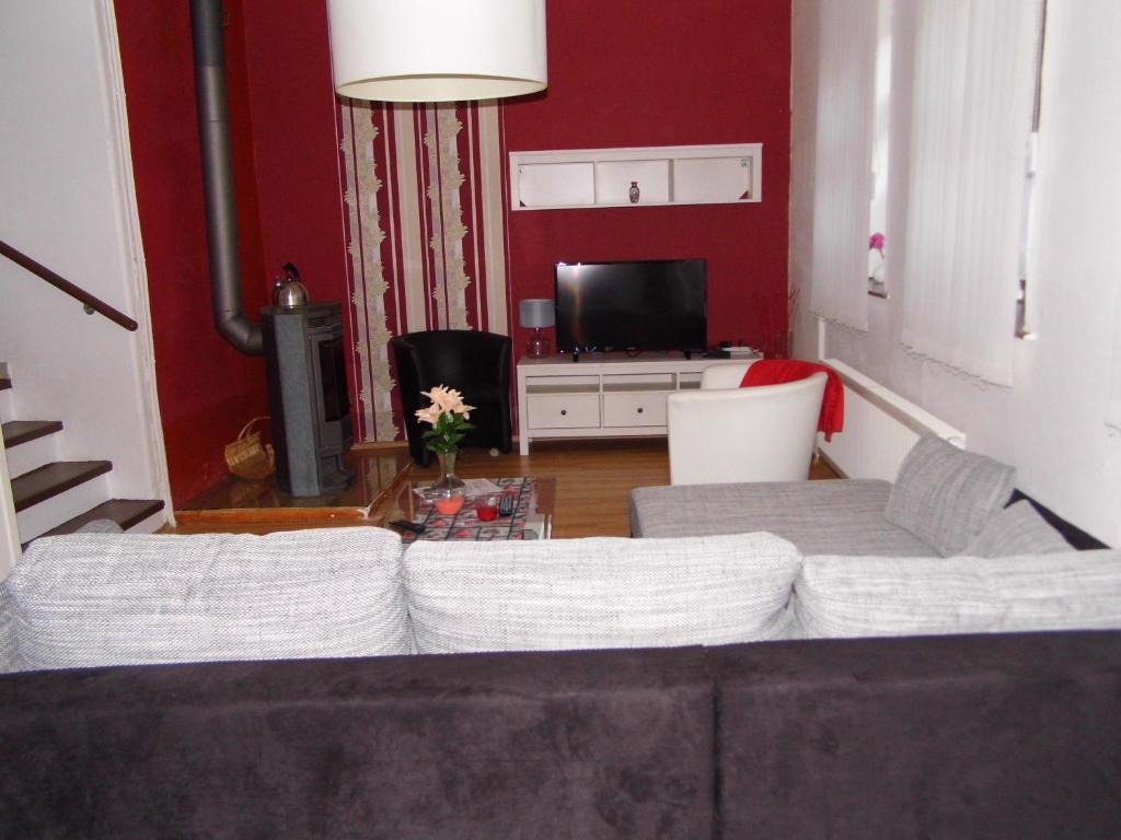 ein Wohnzimmer mit einem Sofa und einem TV in der Unterkunft FerienwohnungQuedlinburg in Quedlinburg