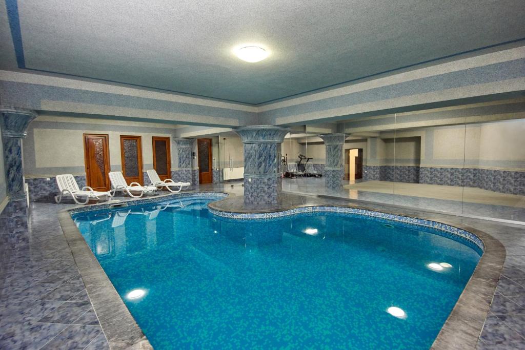 a large swimming pool in a hotel room with chairs at S&L Boutique Hotel in Tbilisi City