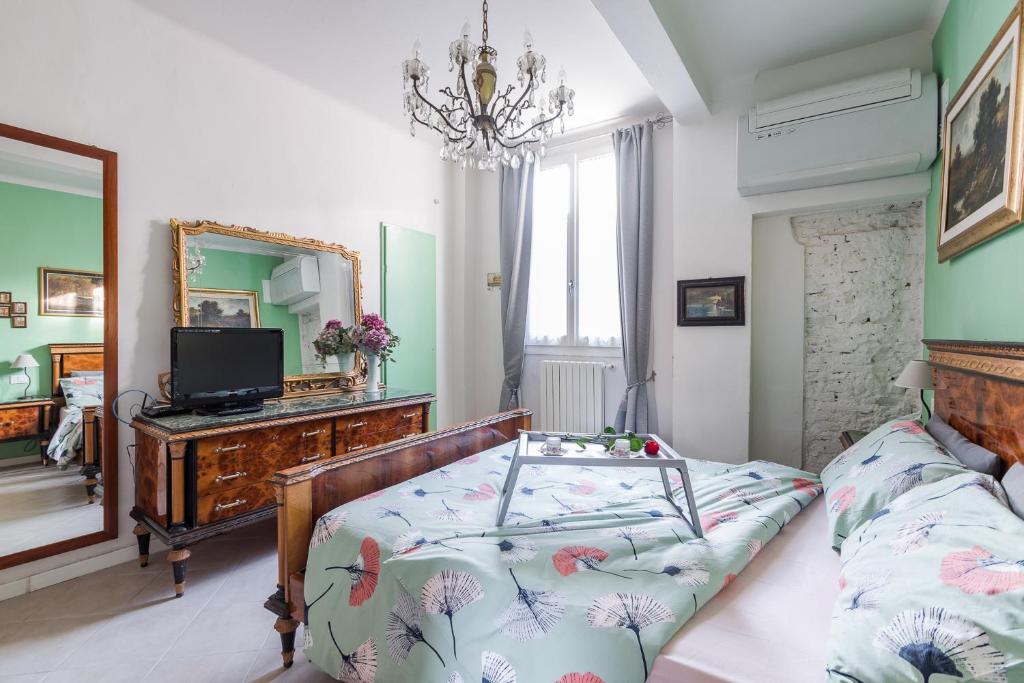 1 dormitorio con 1 cama, TV y espejo en La Colombina, en Bolonia