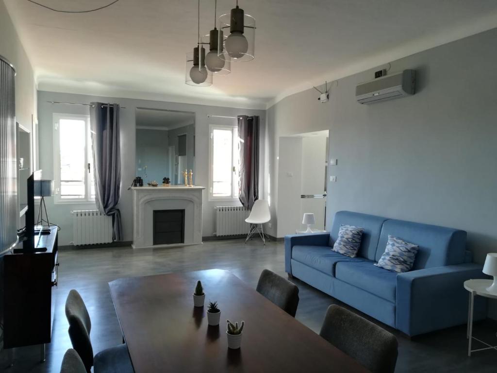 uma sala de estar com um sofá azul e uma mesa em Cavour17 em Sanremo