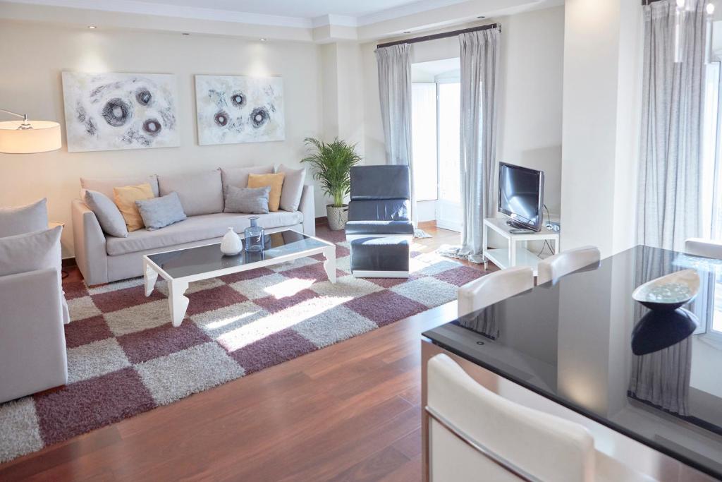 uma sala de estar com um sofá e uma televisão em Apartamentos La Bola Suite em Ronda