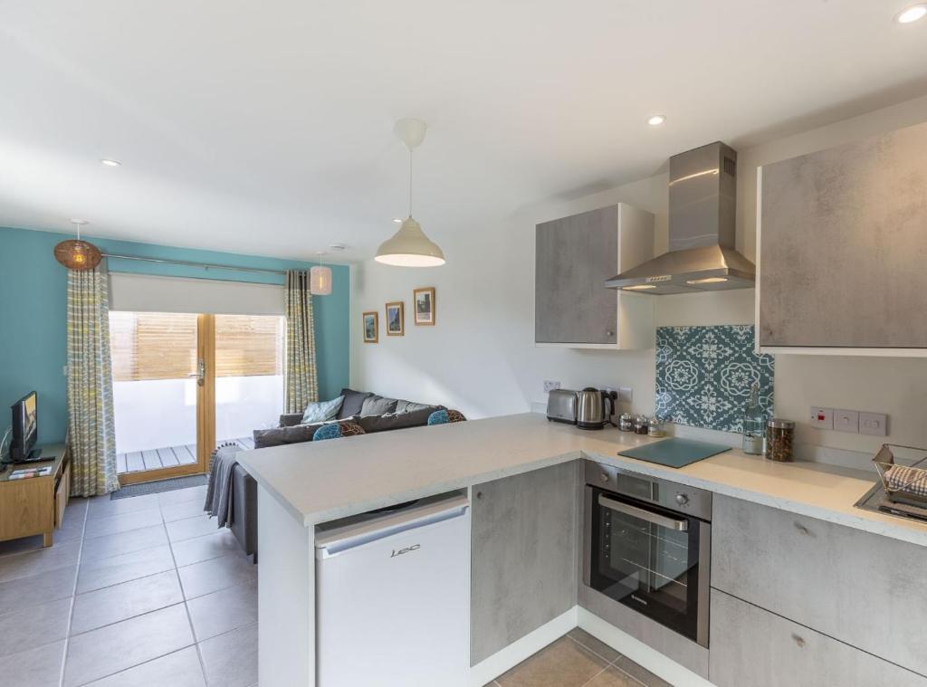 a kitchen and living room with a couch at Stones Throw Studio Apartment Bude Cornwall in Bude