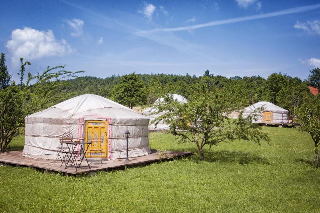 a yurt with a table and a chair in a field at Società Agricola Cacigolara in Borgo Val di Taro