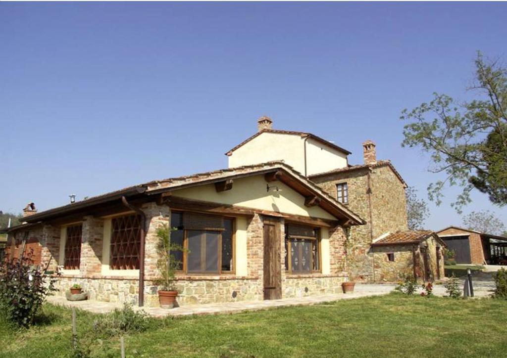 uma grande casa de pedra num campo de relva em La Villa em Lucignano