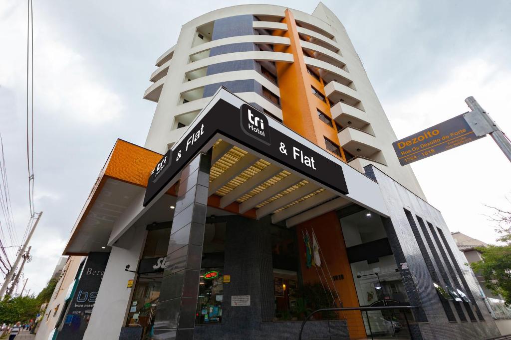 un edificio con un letrero de la calle delante de él en Tri Hotel & Flat Caxias en Caxias do Sul