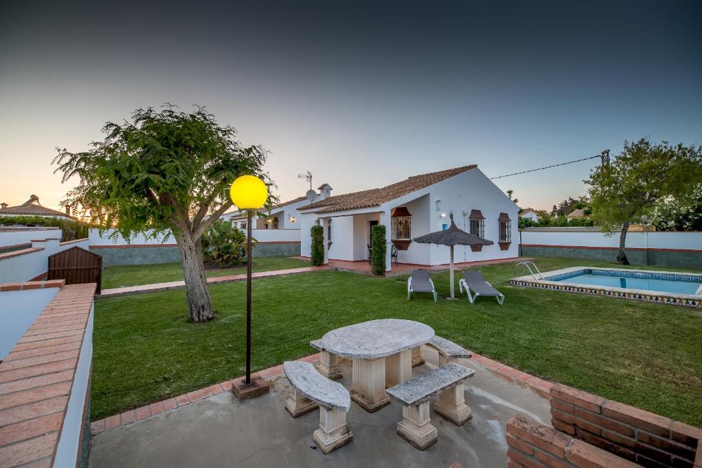 a backyard with a picnic table and a pool at Chalet Pedro II in Conil de la Frontera