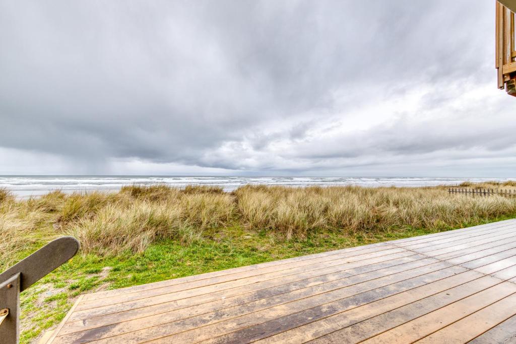 a wooden boardwalk leading to the ocean on a cloudy day at Rockaway Beach Cozy Cabin in Rockaway Beach