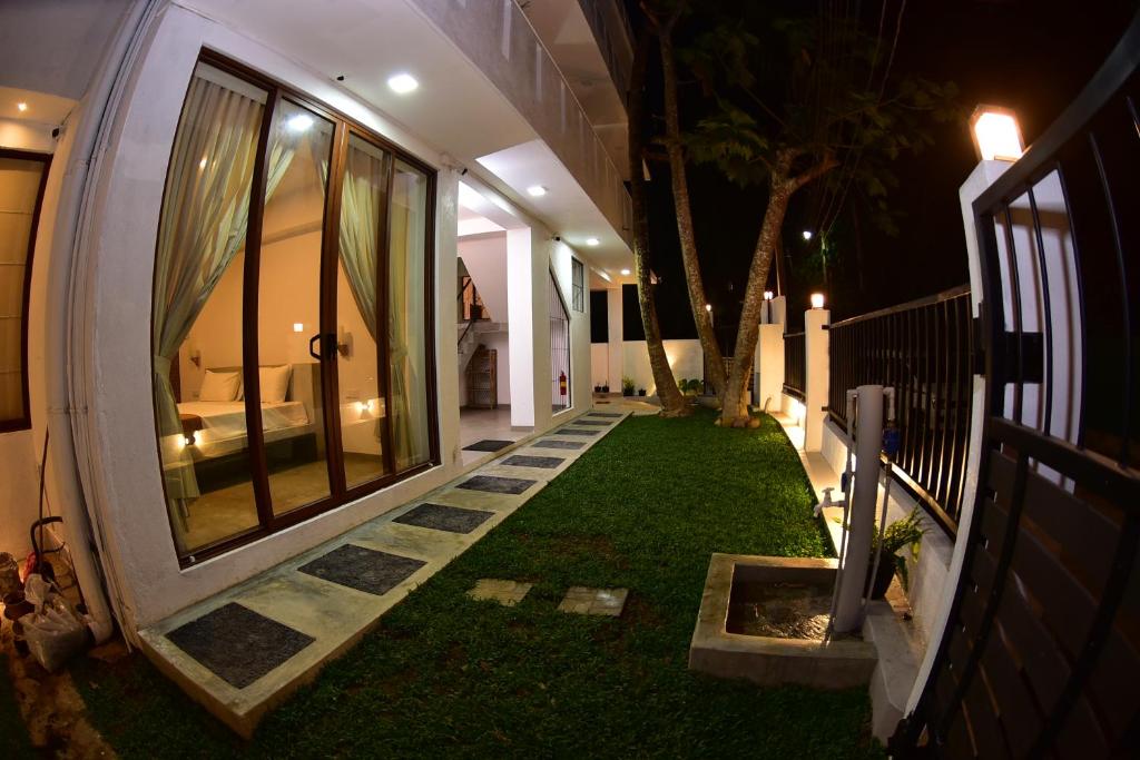 a house with a lawn in the middle of a yard at Lily Holiday Apartments in Hikkaduwa