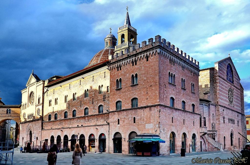 een groot bakstenen gebouw met een klokkentoren bovenop bij Affittacamere Girasole in Foligno