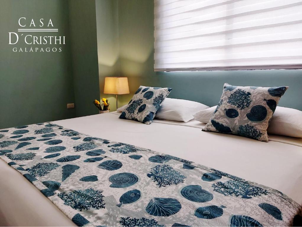 - une chambre dotée d'un lit avec une couverture et des oreillers dans l'établissement Casa D´Cristhi, à Puerto Baquerizo Moreno