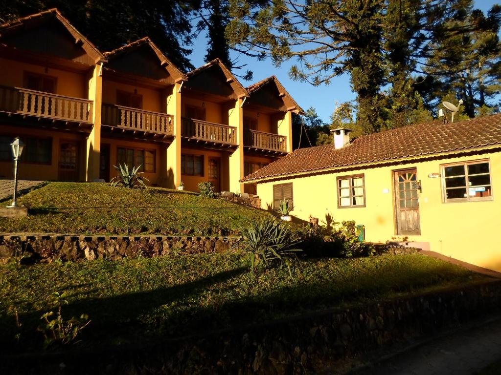 a large yellow house with a yard in front of it at Pousada Sonho Verde in Monte Verde