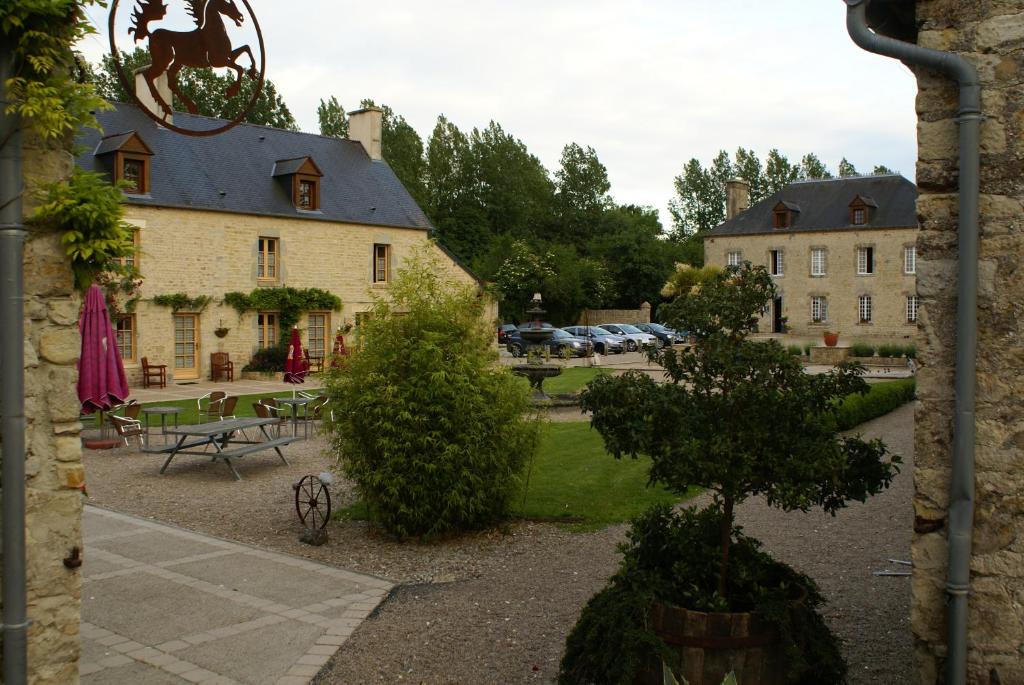 a view of a building and a park with a tree at Domaine Utah Beach - Le Grand Hard in Sainte-Marie-du-Mont