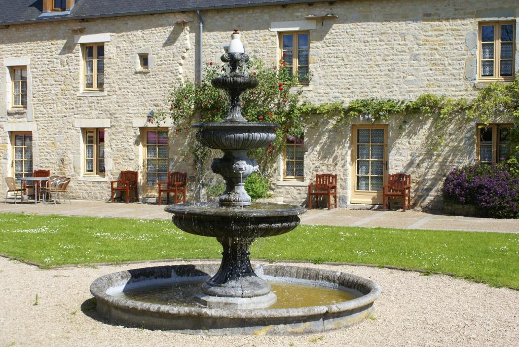 a large fountain in front of a stone building at Domaine Utah Beach - Le Grand Hard in Sainte-Marie-du-Mont