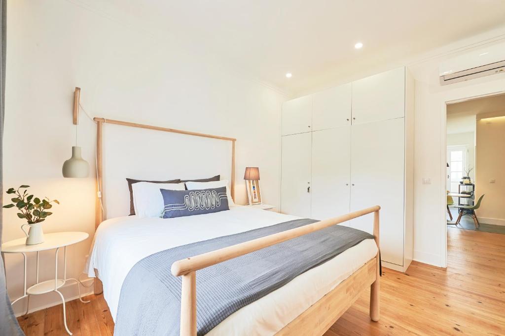 里斯本的住宿－Pina Cozy Home，白色卧室配有一张带蓝色枕头的大床