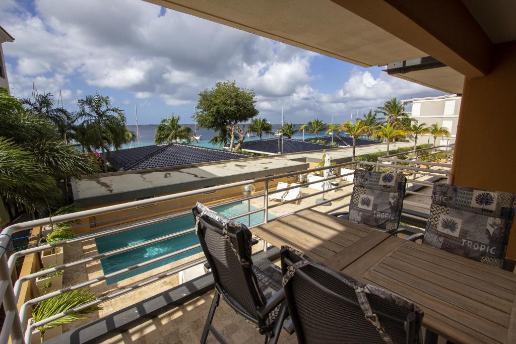 Seaside Apartment Turtle في كراليندايك: شرفة بطاولة وكراسي خشبية بجانب مسبح