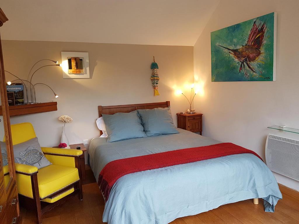 1 dormitorio con 1 cama y 1 silla amarilla en GIVERNY COTTAGE, en Saint-Coulomb