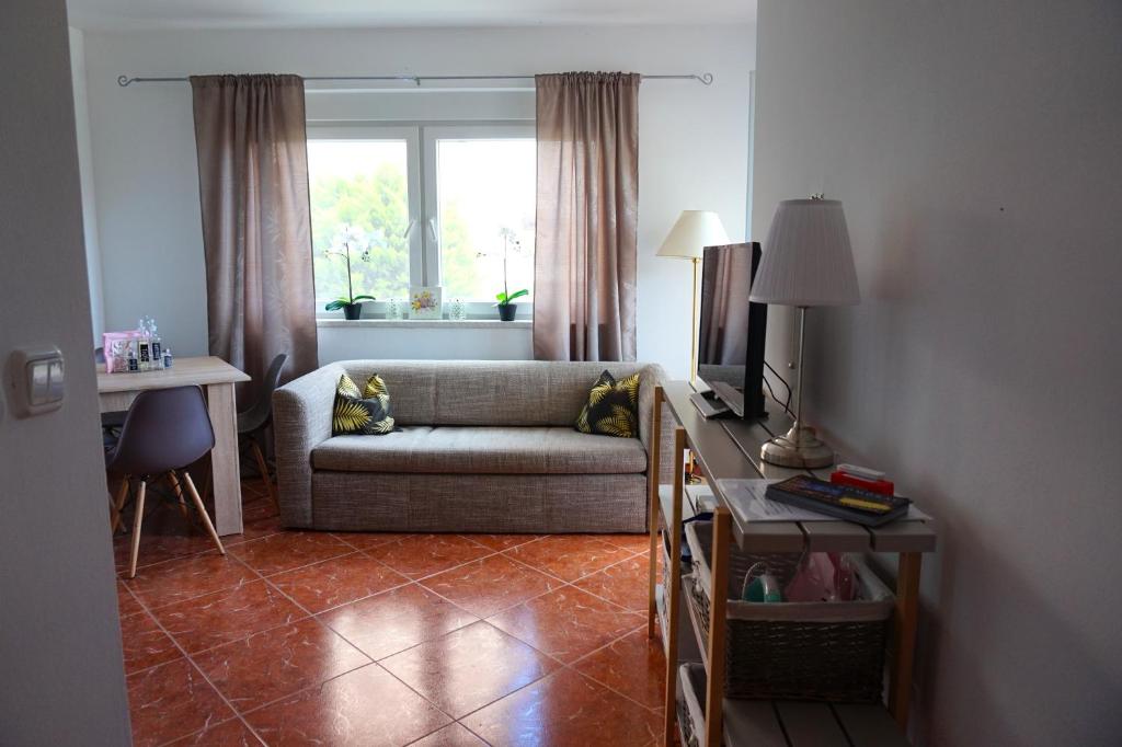 - un salon avec un canapé et une fenêtre dans l'établissement Apartment Munida, à Medulin