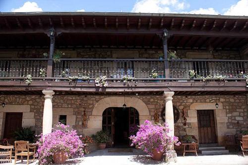 un edificio con un balcón con flores. en Casa Velarde, en Torrelavega
