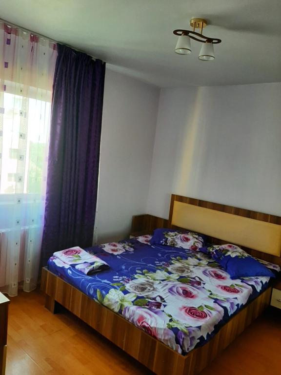 a bedroom with a bed with a blue comforter at Apartament City in Constanţa
