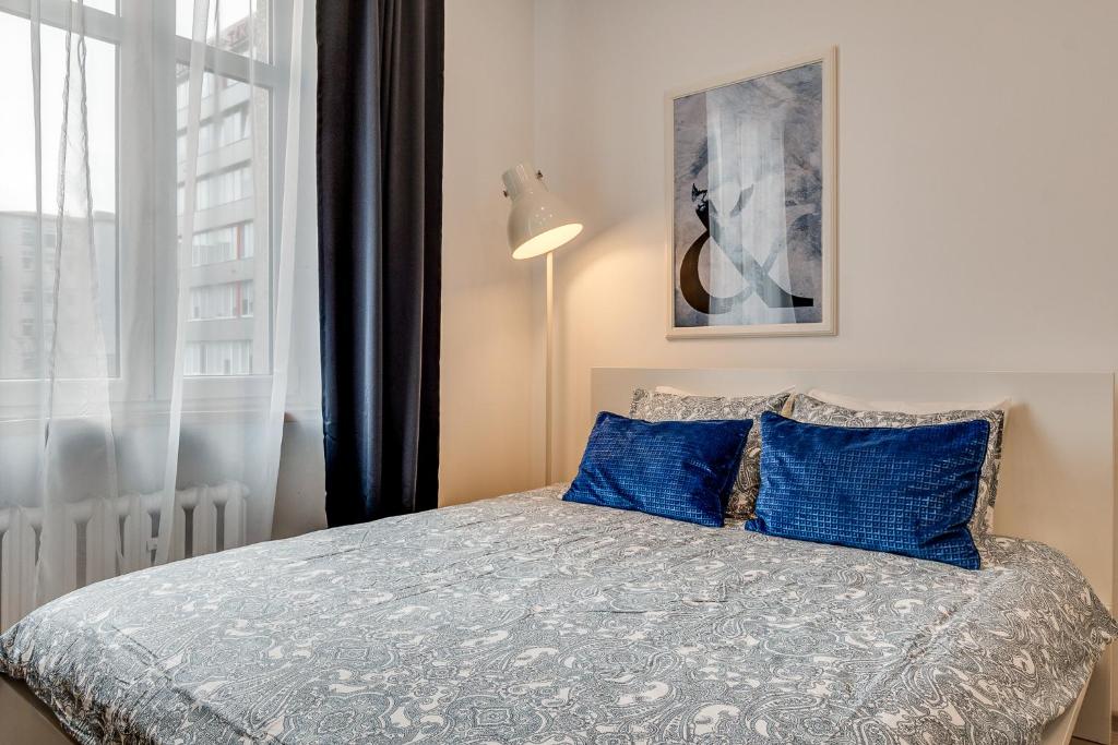 カトヴィツェにあるKATO Apartamenty Centrumのベッドルーム1室(青い枕のベッド1台、窓付)