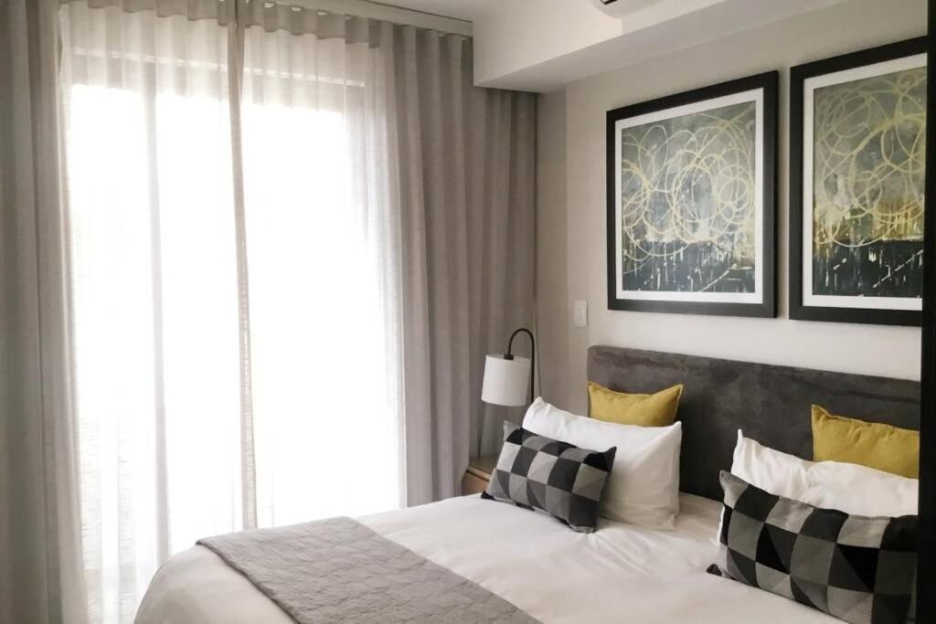 プレトリアにあるRegency Apartment Hotel Menlynのベッドルーム1室(ベッド1台、白黒の枕付)