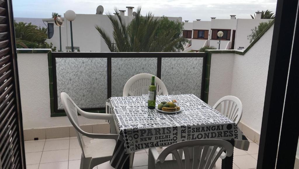 - Balcón con mesa y sillas y botella de vino en Calle Hesperides en Costa Del Silencio