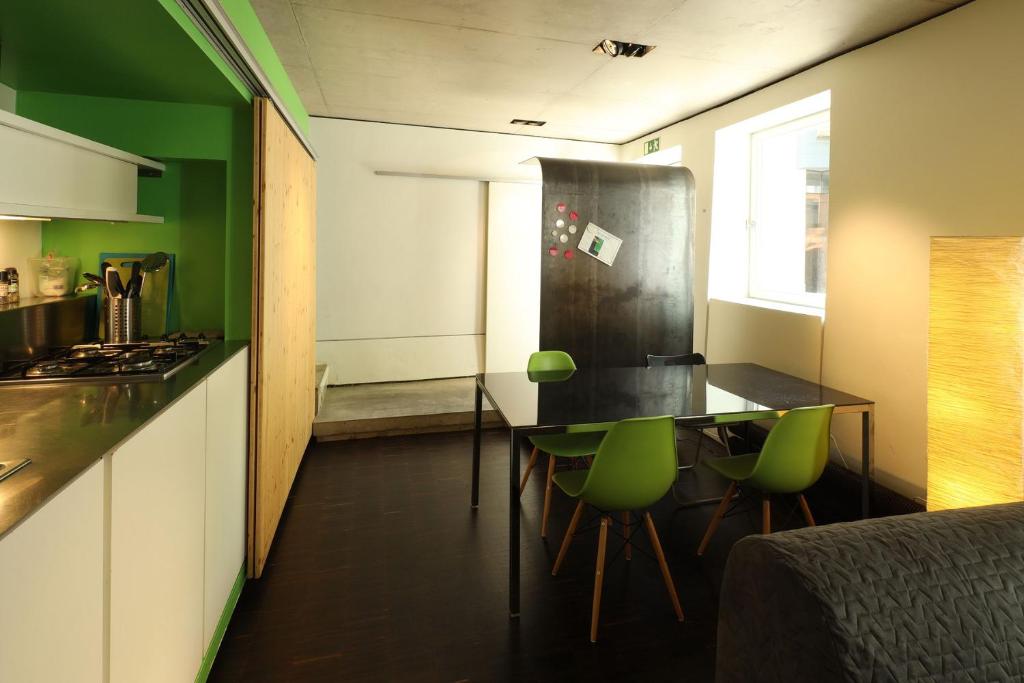 une cuisine avec une table et des chaises vertes dans l'établissement ART_is(t) House - an unique design experience, à Luxembourg