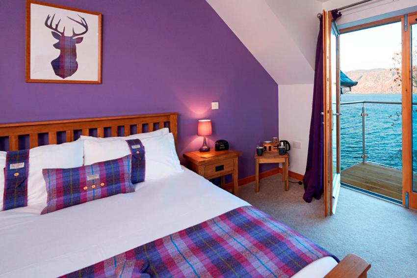 a bedroom with a bed and a view of the water at Balachladaich Loch Ness B&B in Dores