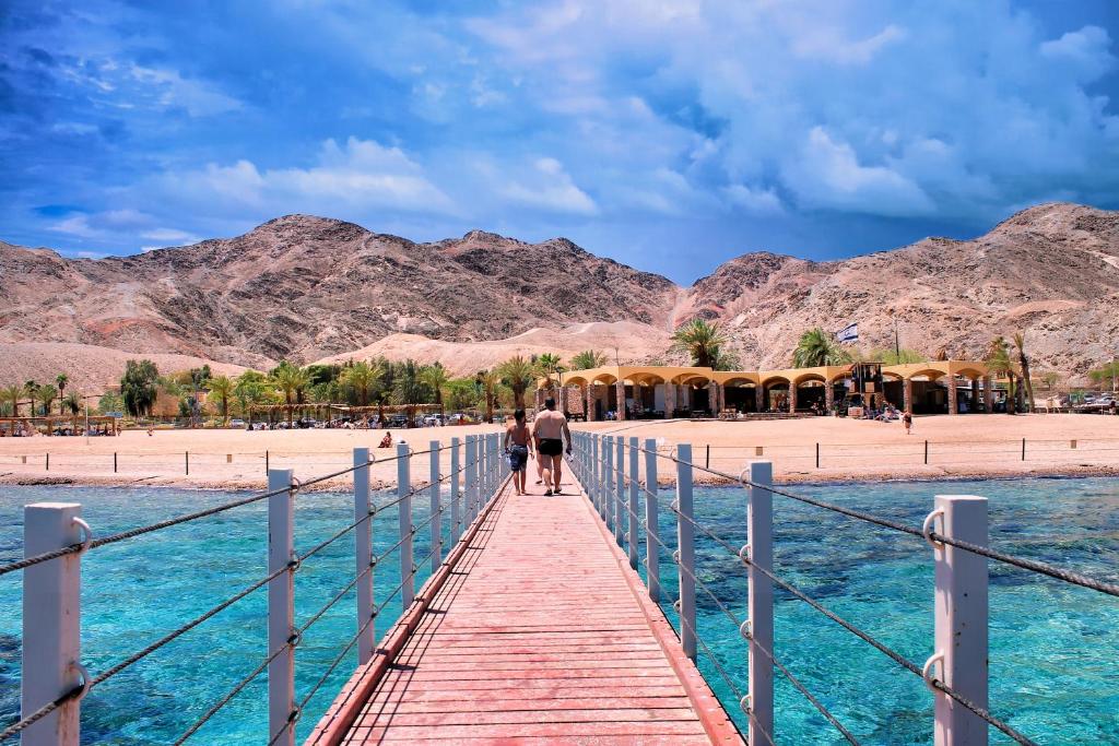 a bridge over the water with mountains in the background at Sweet Home, Only 7 Min to the beach! in Eilat