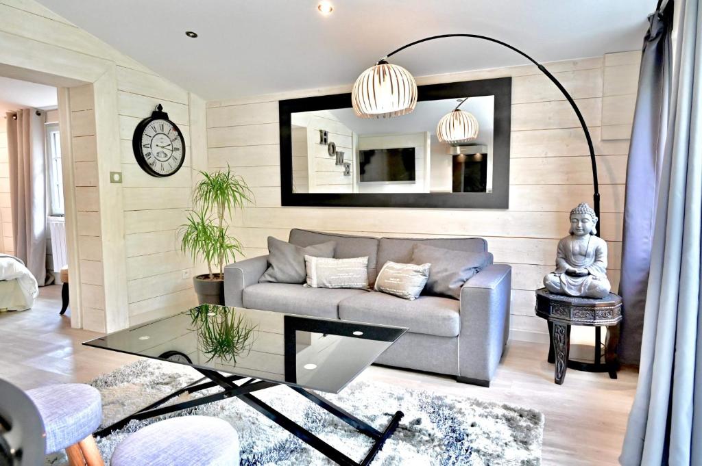 ein Wohnzimmer mit einem Sofa und einem Spiegel in der Unterkunft Chalet cosy de Plage entre Biarritz et Hossegor in Tarnos