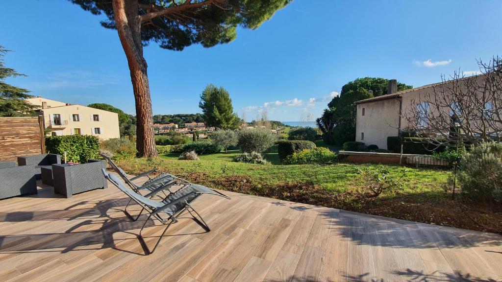 une banquette assise sur une terrasse en bois dans une cour dans l'établissement French Riviera - Vaugrenier, à Villeneuve-Loubet