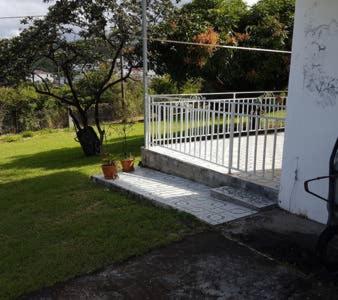 een witte poort in een tuin met een boom bij Villa Soleil DZ in Baillif