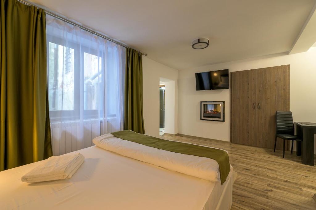 a bedroom with a large bed and a window at Apartment Queen Bridge in Sibiu