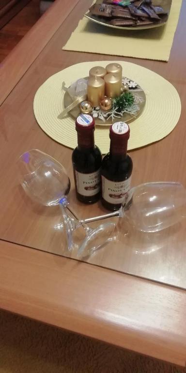 a table with three bottles and a plate of food at Apartment M&amp;A in Osijek