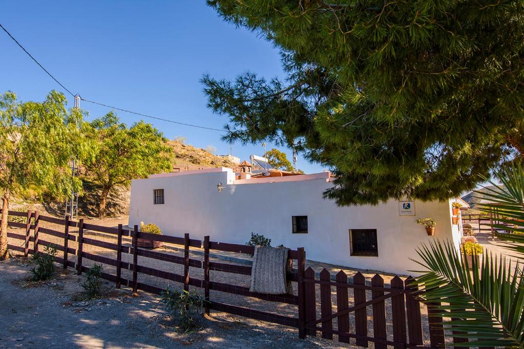 una casa blanca con una valla delante en Cortijo 4 Elementos, en Lucainena de las Torres