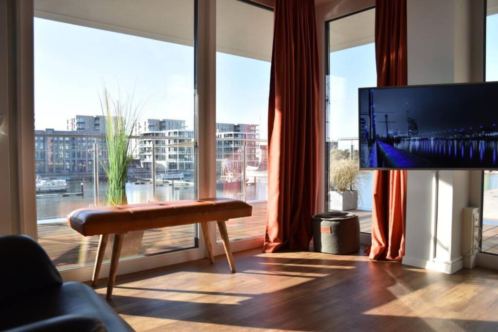 a living room with a tv and a large window at LOFT Port Marina 26 in Bremerhaven