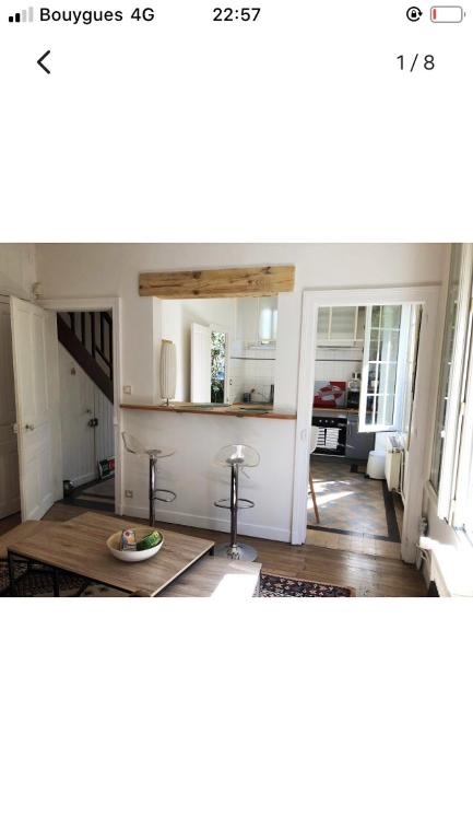 a kitchen with a table in the middle of a room at Maison cocooning avec petit jardin privatif in Limoges