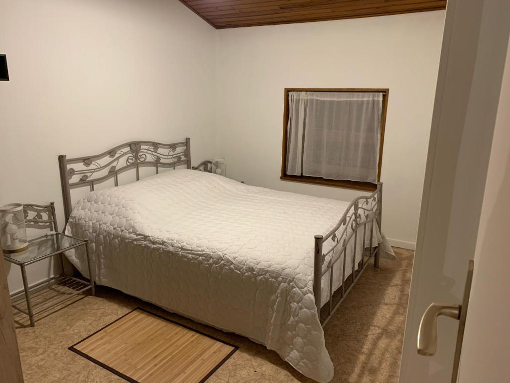 een slaapkamer met een bed, een spiegel en een raam bij La Caminada in Fougax-et-Barrineuf