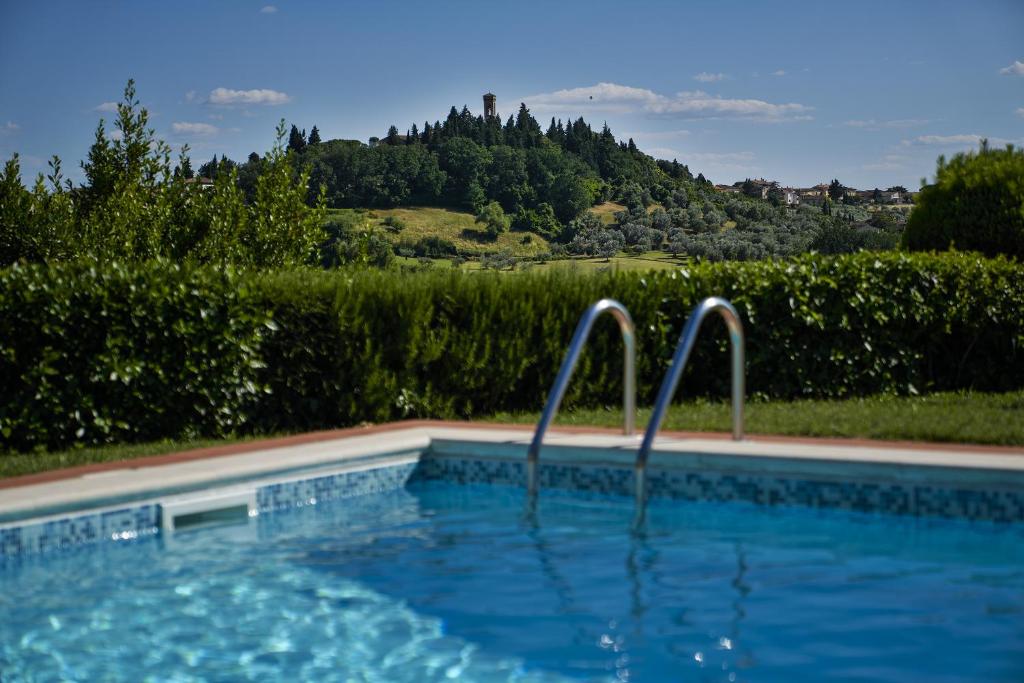 a swimming pool with two metal bars in a yard at Villa il Borraccio in Tavarnelle in Val di Pesa