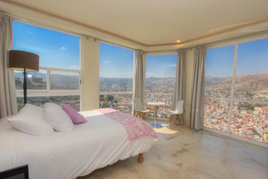 um quarto com uma cama e janelas grandes em La Vista em Guanajuato