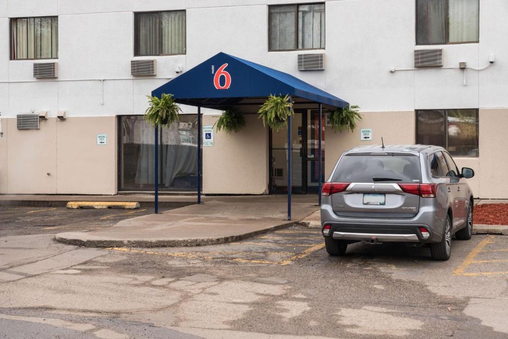 a car parked in a parking lot in front of a building at Motel 6-Saint Paul, MN - I-94 in Saint Paul