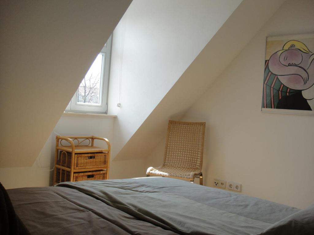ein Schlafzimmer mit einem Bett, einem Fenster und einem Stuhl in der Unterkunft Am Inselmarkt in Werder