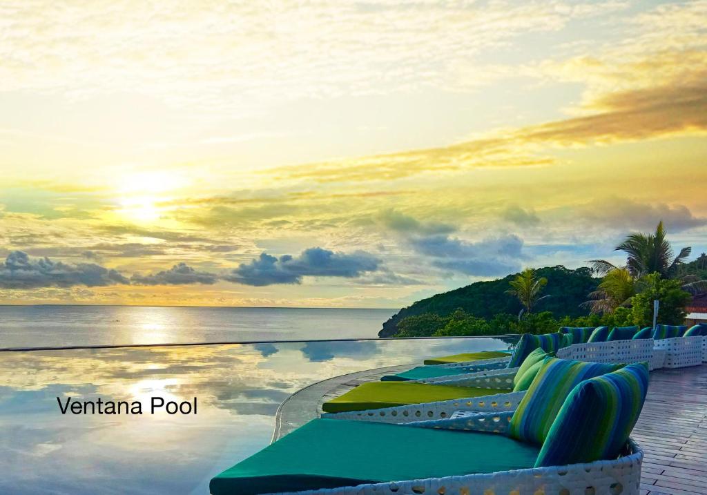a row of chaise lounges on the edge of a resort pool at Fairways and Bluewater Boracay in Boracay