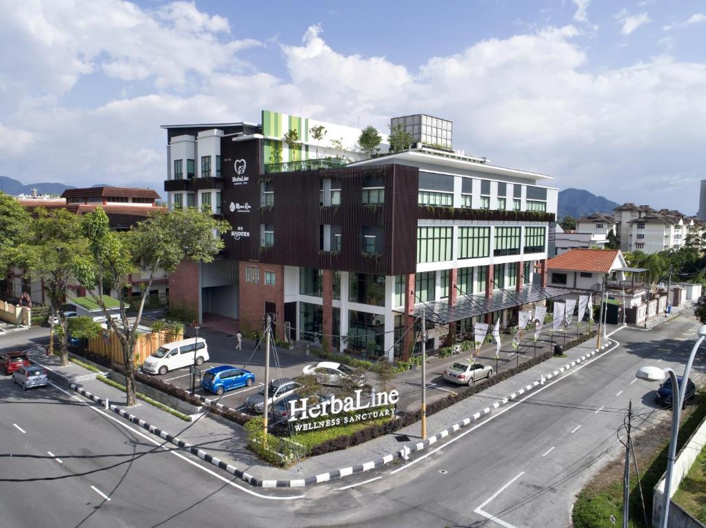 a large building on a city street with cars parked at Sojourn Spa Hotel Ipoh in Ipoh