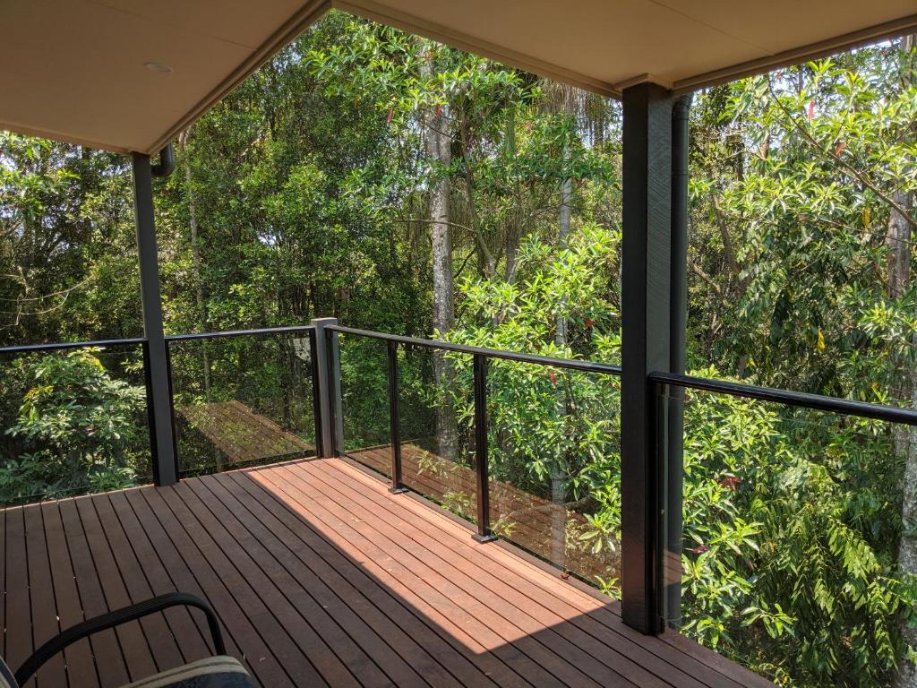 a screened porch with a view of the forest at Treetops Haven in Maleny