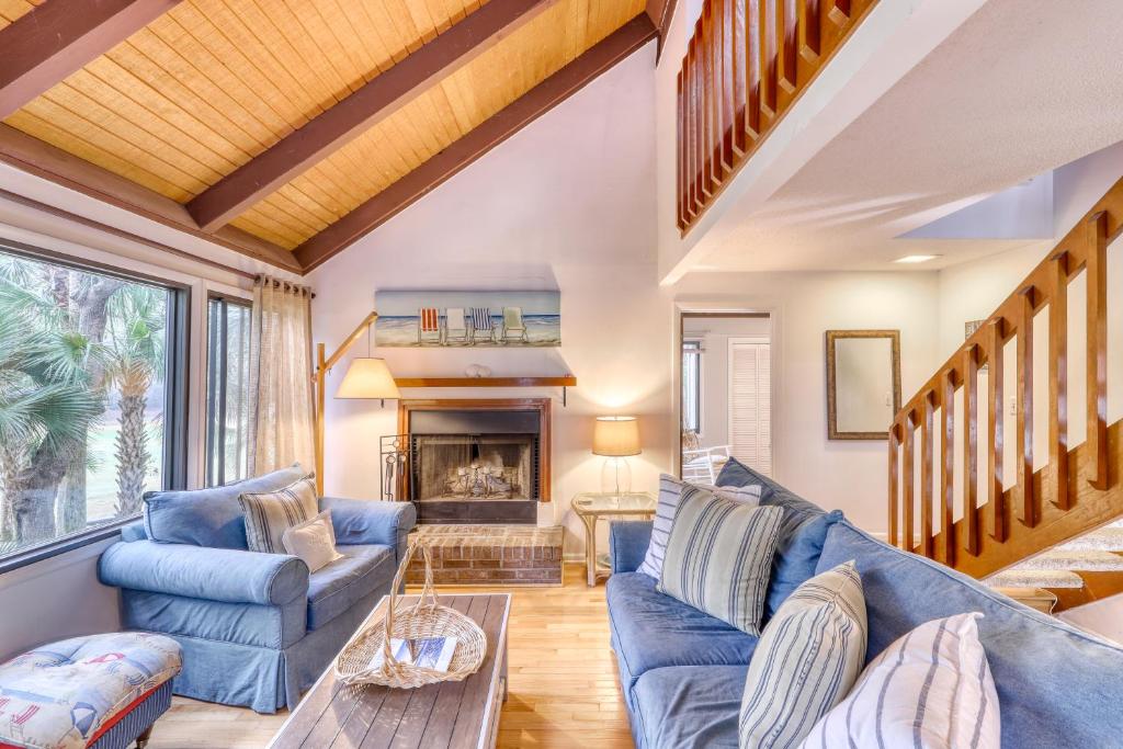 a living room with blue couches and a fireplace at 809 Treeloft Cottage in Seabrook Island