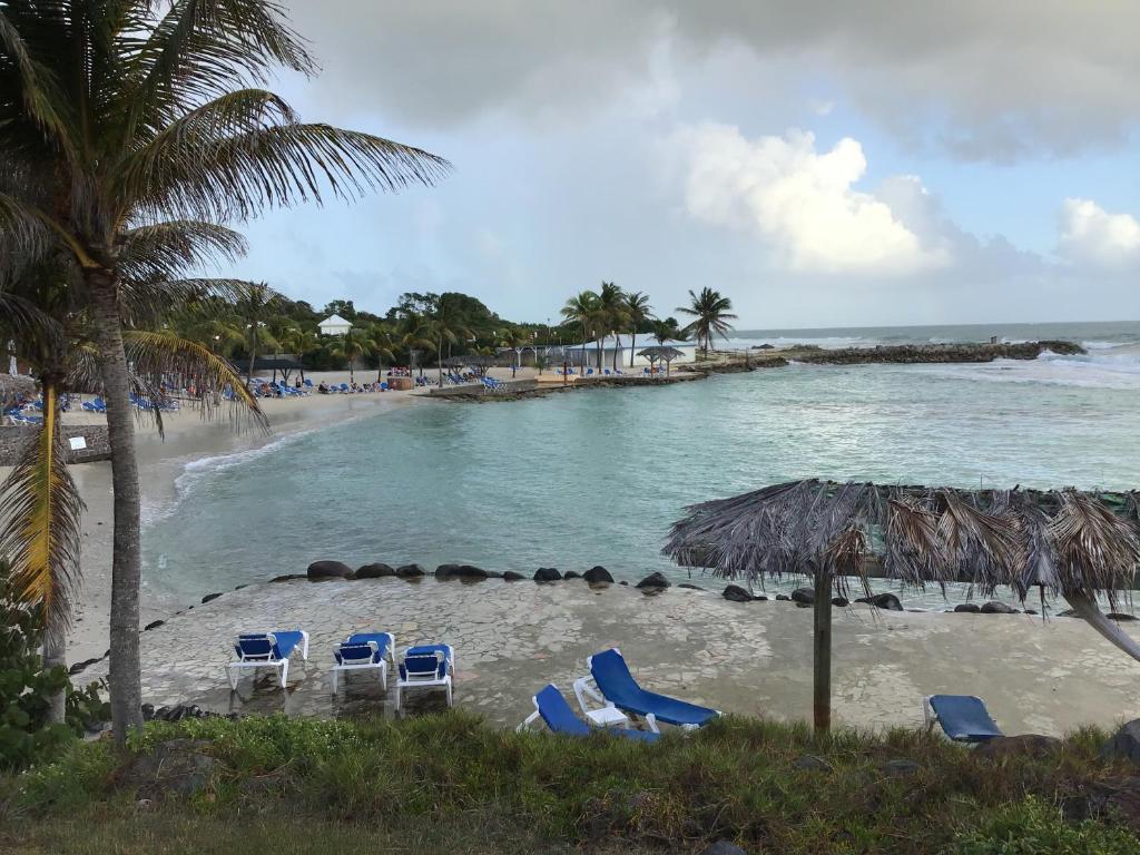a beach with lounge chairs and the ocean at Gwada dream in Saint-François